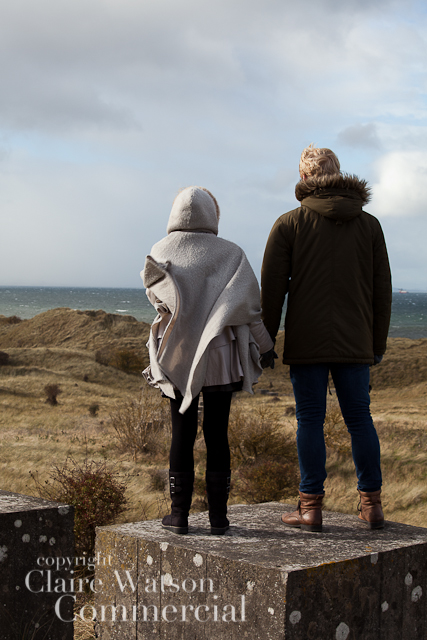 couple standing on a concrete pillar at Gullane